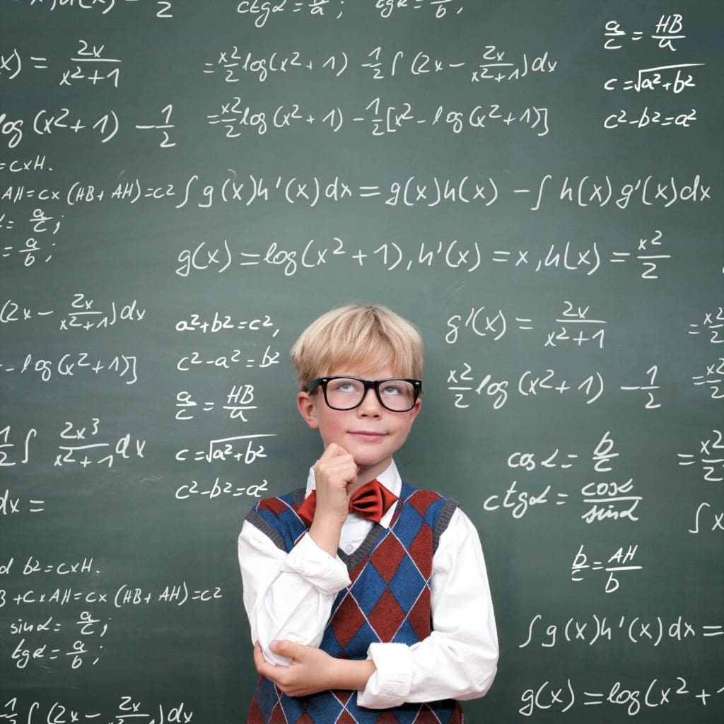 boy in front of chalkboard covered with math equations